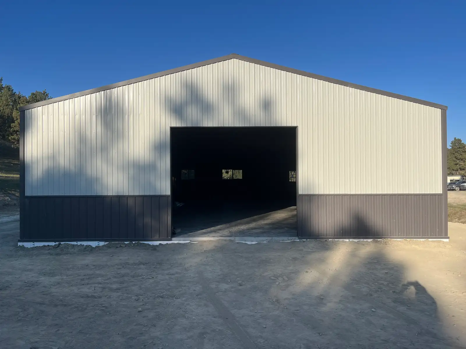 Finished white and gray stick-framed shop home with a large overhead door