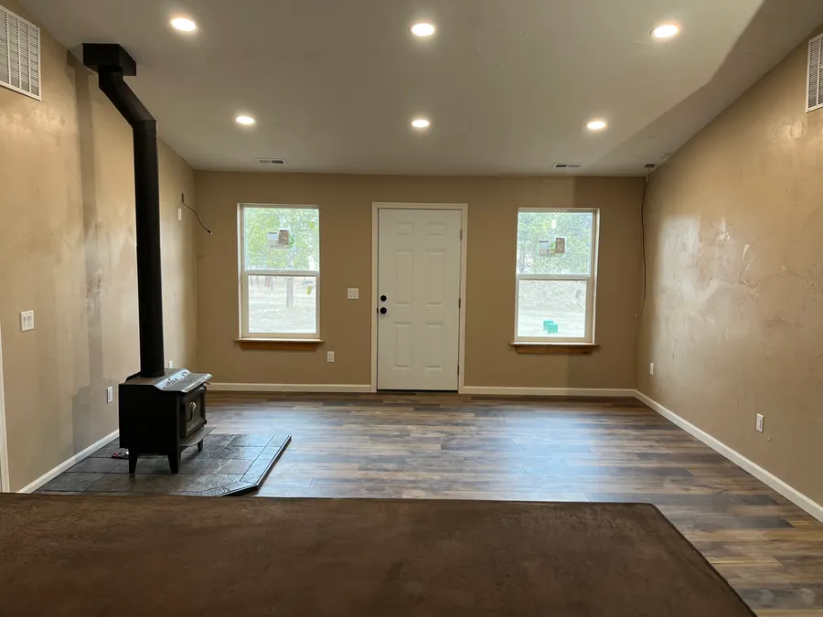 Finished living space with wood stove and plank flooring