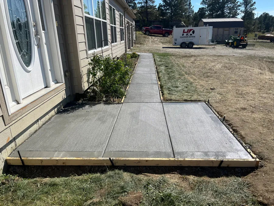 New concrete walkway and entry pad poured beside a home