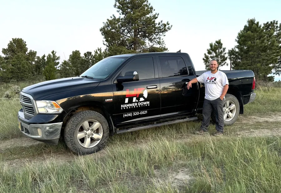 Bryan, owner of Hammer Down Construction, beside the company truck